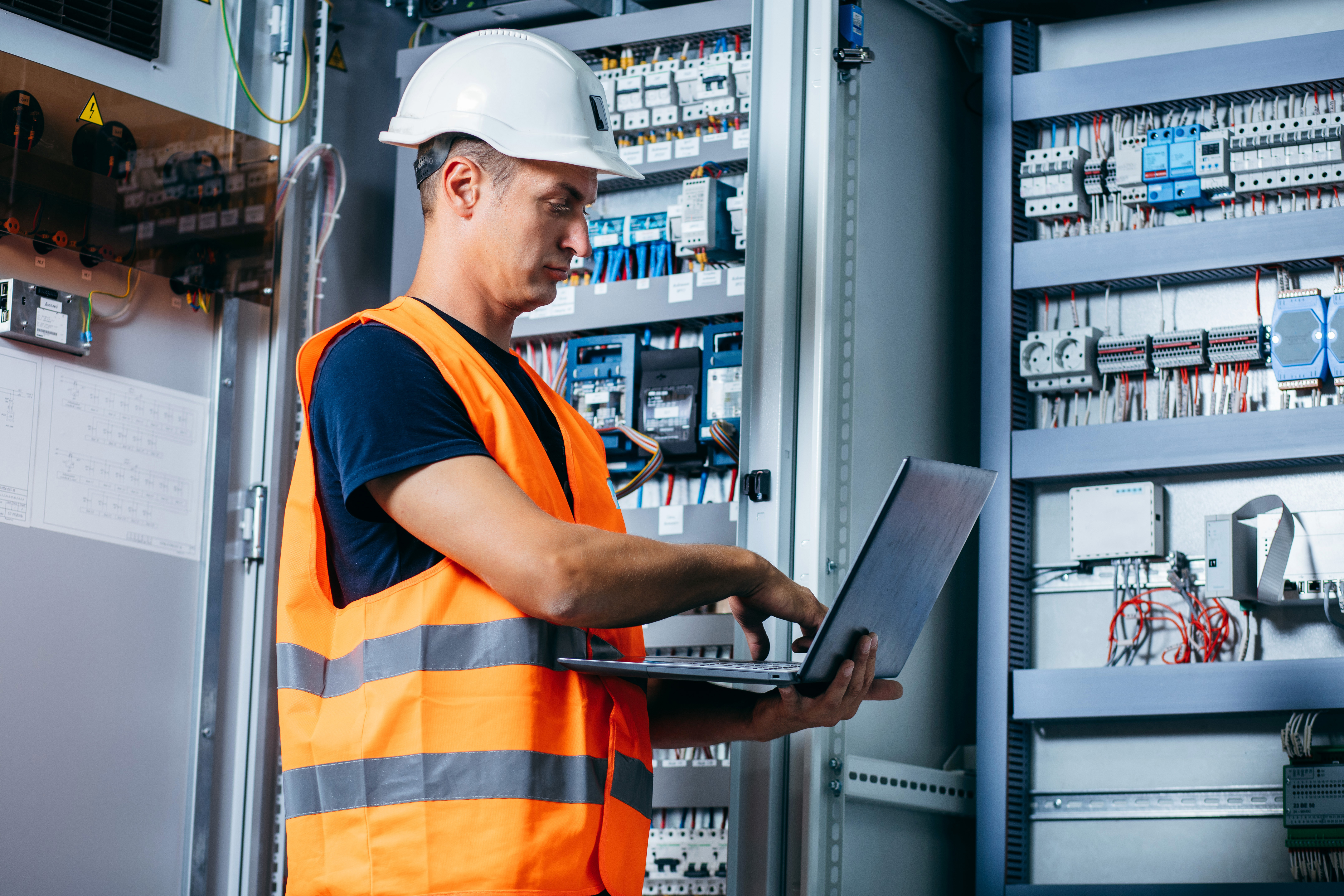 Engineer working with a laptop beside connected infrastructure