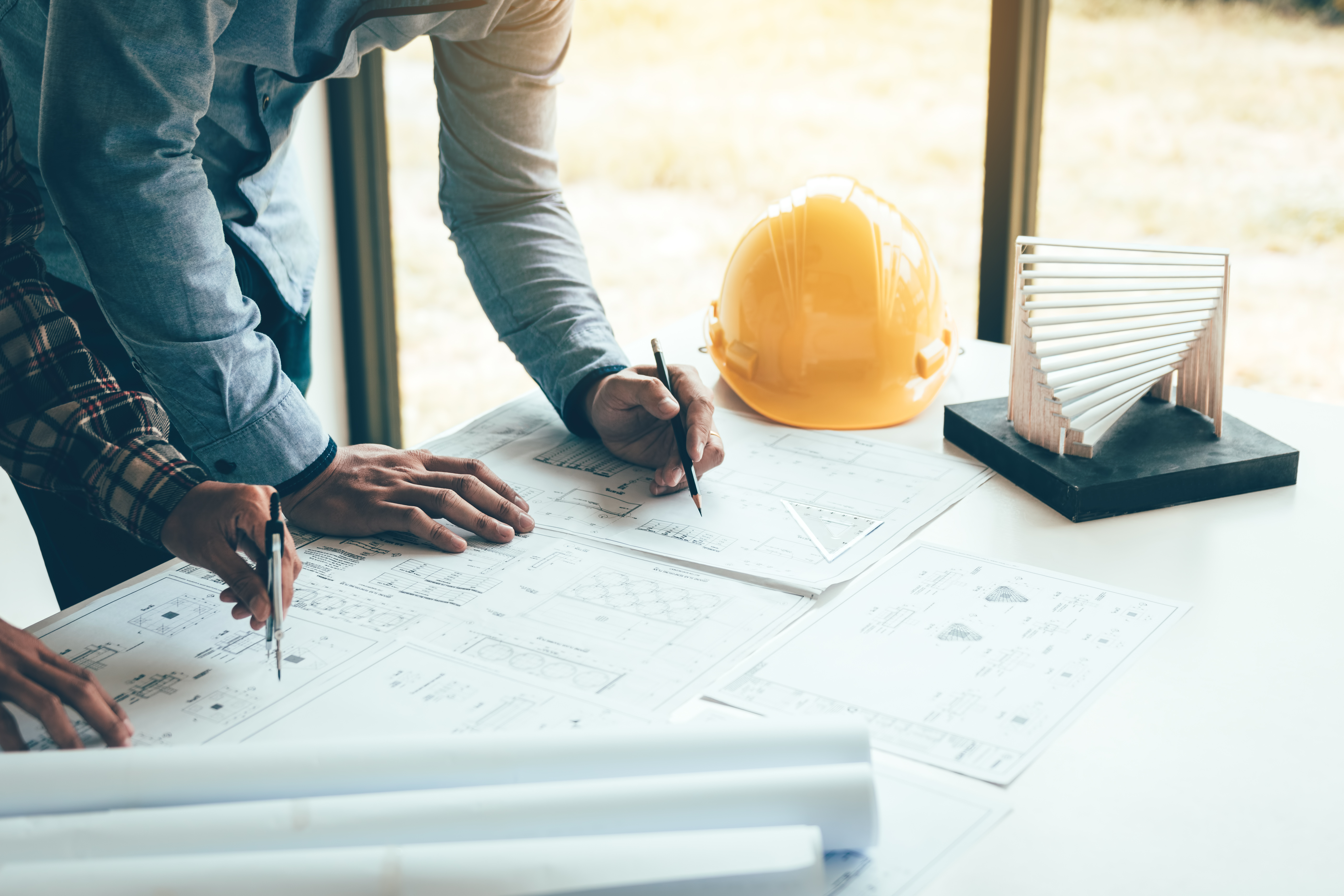 Two engineers reviewing blueprints and project documentation together